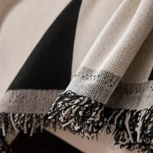 Black and white geometric sofa cover blanket with decorative fringes and knitted texture