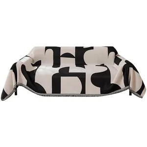 Modern black and white geometric sofa cover blanket with decorative fringe details