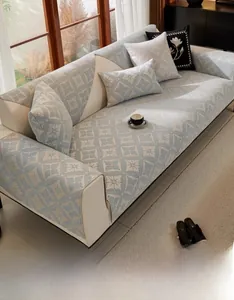 Detail of blue-grey chenille sofa cover showing white geometric flower patterns and texture