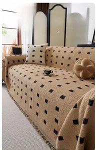 Detail of khaki checkered textured chenille sofa throw with soft fringe edges