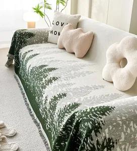 Detailed close-up of knitted sofa throw with forest pattern and fringed edges