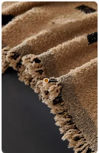 Detail of hand-woven tassels and thick knit texture on a minimalist sofa cover