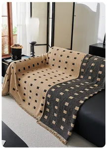 Detail of checkered sofa throw with fringe showing thick texture and weave pattern