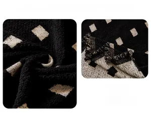 Close-up of black boucle yarn sofa cover with white diamond pattern and fringe details