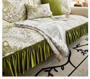 Detail of floral sofa cover with olive green pleated velvet trim in a rustic interior