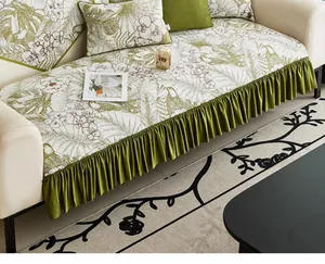 Detail of tropical leaf print sofa cover with olive green pleated ruffles and matching pillows