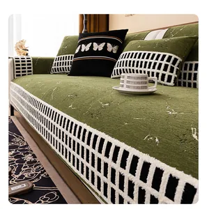 Detailed close-up of dark green chenille sofa cover with woven checkerboard trim