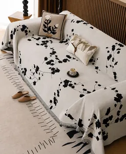 Detail of chenille sofa cover showing beige floral pattern and fringe edge craftsmanship