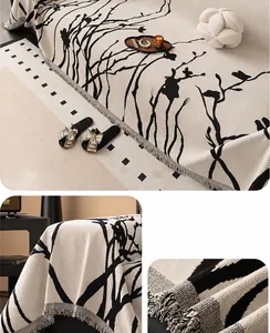 Detailed texture of chenille sofa cover with black tree branch pattern and tassel edges