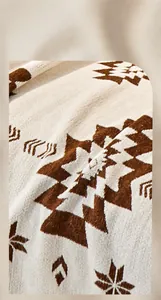 Gros plan d'un jeté de canapé en chenille avec motifs géométriques et texture tricotée
