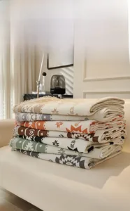 Macro shot of folded jacquard blankets with geometric ethnic patterns and tassel details