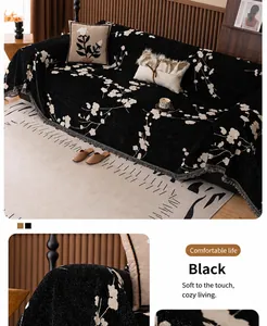 Close-up of black chenille sofa cover featuring white plum blossom patterns and fringe edges