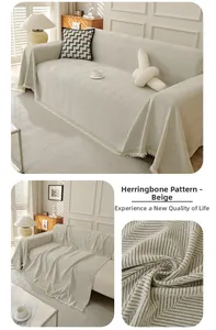 Close-up of beige herringbone sofa cover featuring textured weaving and tassel edge detail