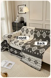 Detail of bohemian sofa cover with Aztec geometric patterns and thick tassel fringe edges