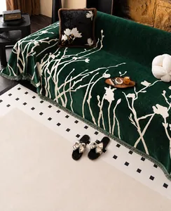 Deep green chenille sofa cover with floral pattern and decorative tassel edge detail