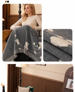 Close-up of grey chenille sofa cover with floral jacquard pattern and handmade tassels
