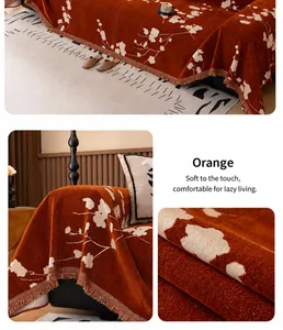 Detail of orange chenille sofa cover featuring white plum blossom patterns and fringe trim