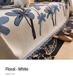 Detail of chenille sofa cover featuring blue floral patterns and elegant fringe edges