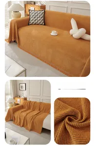 Detail of orange herringbone chenille sofa throw with decorative tassels and texture