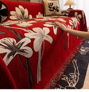 Close-up of vintage red chenille sofa cover with floral jacquard and tassel details
