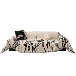 Copridivano in ciniglia beige con motivi a rami neri ed eleganti frange sui bordi