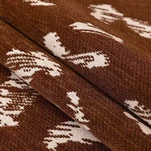Brown chenille sofa cushion with white swan pattern and vertical ribbed texture