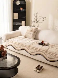 Detail of chenille sofa cushion with black wavy edges and khaki grid pattern
