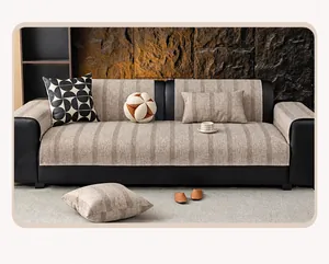 Detail of minimalist striped linen sofa cover with rich woven texture on black leather