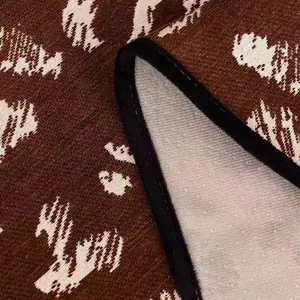 Brown and white chenille animal print sofa cushion with non-slip backing and black edging