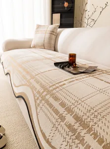 Close-up of chenille sofa cover with plaid jacquard pattern and wavy scalloped edges