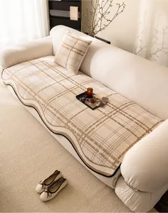 Detail of cream chenille sofa cushion with brown quilted pattern and wavy black trim