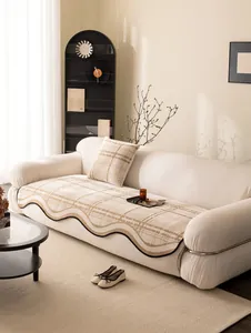 Detail of beige quilted sofa cushion with classic plaid pattern and black wavy edges
