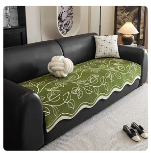 Close-up of green chenille sofa cover with floral patterns and wavy scalloped edges