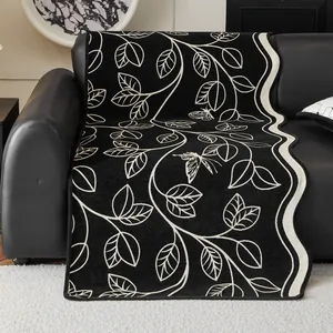 Vintage Chenille sofa cover with butterfly and leaf patterns on a black leather sofa