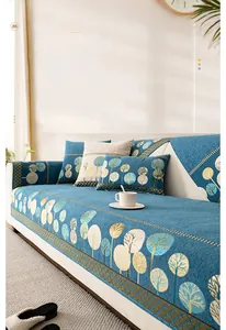 Détail de la housse de canapé en chenille bleue avec motifs d'arbres dorés de style nordique