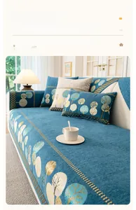 Détail de la housse de canapé en chenille bleue avec motifs de feuilles dorées