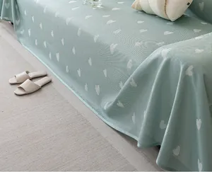 Detail of light green cooling sofa cover with white heart patterns and woven texture