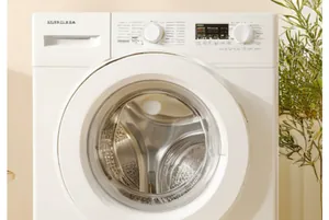 Close-up of the front panel of the white front-load washing machine with control knobs