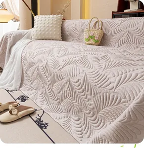 Close-up of cream quilted sofa cover with textured feather pattern and soft fabric finish