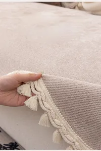 Detail of beige jacquard chenille sofa cover featuring decorative tassel edging and non-slip texture