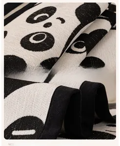 Close-up of thick chenille fabric with panda pattern and durable black stitched edges