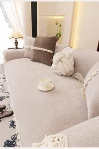 Detail view of beige chenille sofa cover showing rich texture and decorative fringes