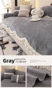 Detail of grey washed cotton sofa cushion with striped corduroy texture and white tassels