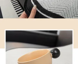Détail du bord d'un tapis jacquard en chenille aux motifs géométriques noirs et blancs