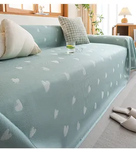 Detail of mint green cooling sofa cover featuring a white heart pattern and breathable texture