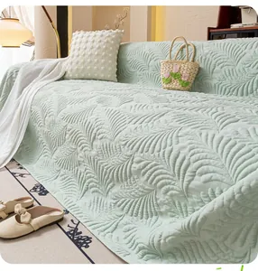 Detail of light green cooling sofa cover with embossed leaf patterns and thick texture