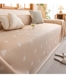 Macro detail of beige cooling sofa cover with white heart jacquard knitted texture