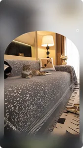 Detail der grauen Chenille-Sofaabdeckung mit weißen Punkten und elegantem Fransenrand