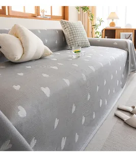 Detail of grey knitted sofa cover featuring white heart jacquard and soft cooling fabric