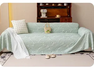 Detail of light green sofa cover with embossed leaf texture and soft fabric finish